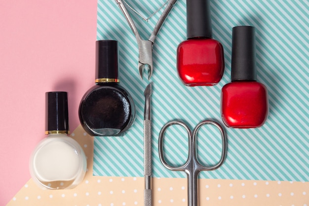 Tools for manicure on a pink and blue background. Nail files, scissors and nail polishes top view. Nail Salon, Beauty Salon