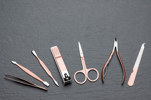 Tools of a manicure set on a grey stone table with copy space