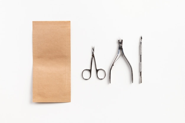 Tools for the manicure with paper bag on white table. Sterilization of instruments healthcare concept