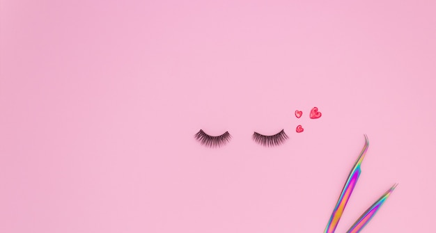 Tools and patches for eyelash extensions and artificial eyelashes on a pink background