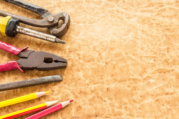 Tools and pencil on old paper background