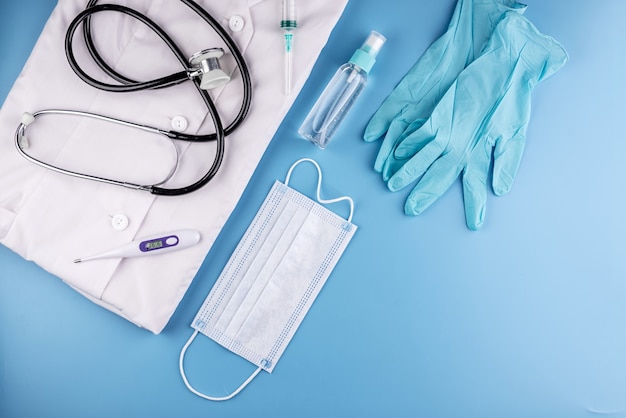 Инструменты и средства защиты для врача на синем фоне