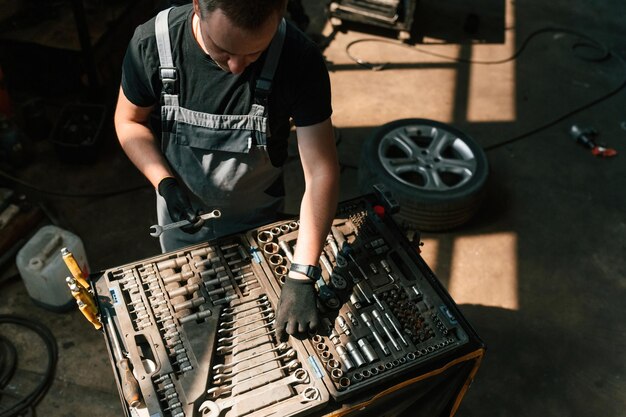 Инструменты для ремонта в коробке Человек работает в автосалоне