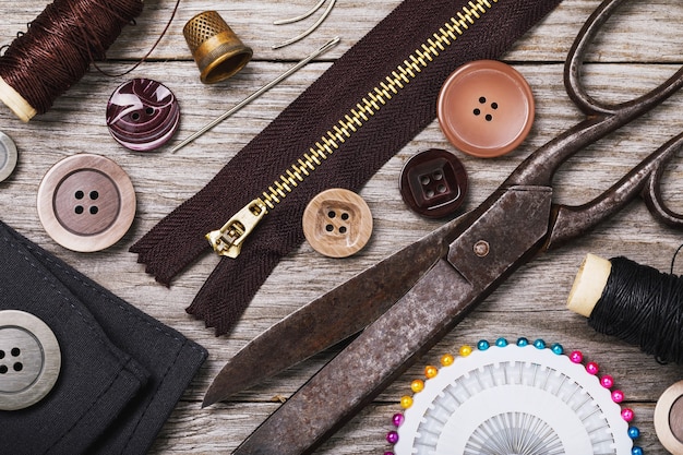 Tools for the repair of clothes on a wooden table top view