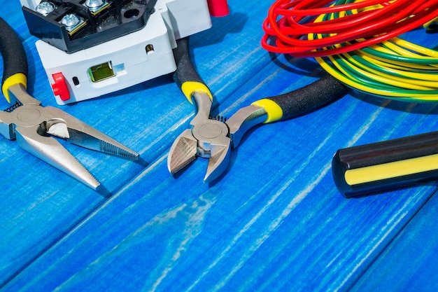 Tools and spare parts for master electrician on blue wooden boards