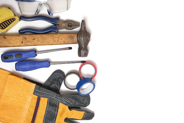 Tools of worker, on white background, screwdrivers, duct tape, pliers and safety glasses.