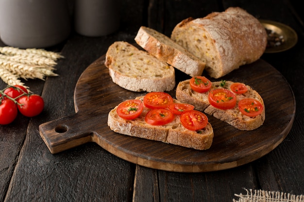 Toosts met tomaten en brood op een bord op hout