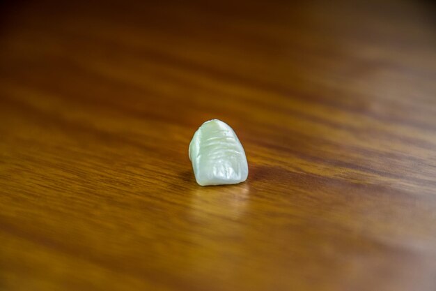 Photo tooth metal ceramic crown on the table denture made of metal ceramics