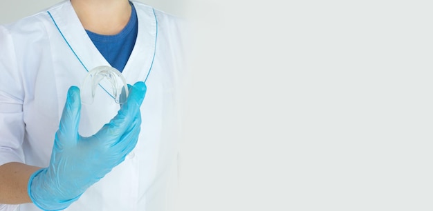 tooth whitening a tooth mold in doctors hand dental beauty treatment teeth retaining tools after braces concept orthodontics dental doctors hands holding silicone mouth guard