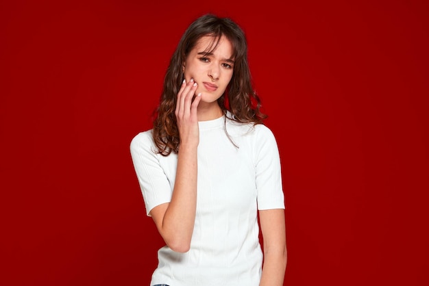 Mal di denti giovane donna tocca la guancia soffrendo improvviso dolore ai denti clinica dentale e assicurazione medica