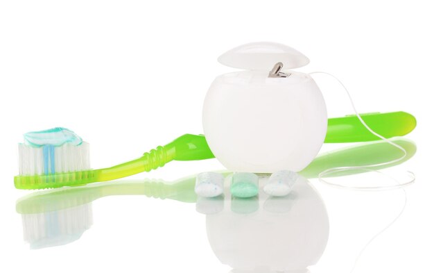 Зубная щетка жевательная резинка и зубная нить изолированы на белом