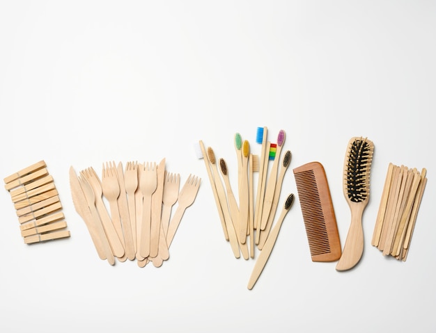 Toothbrush, comb, clothespin and other wooden items on a white background, top view, zero waste