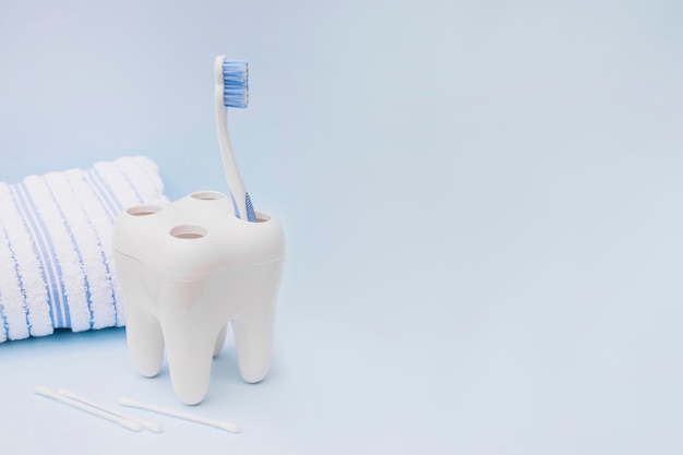 Toothbrush; cotton swab and towel on blue background