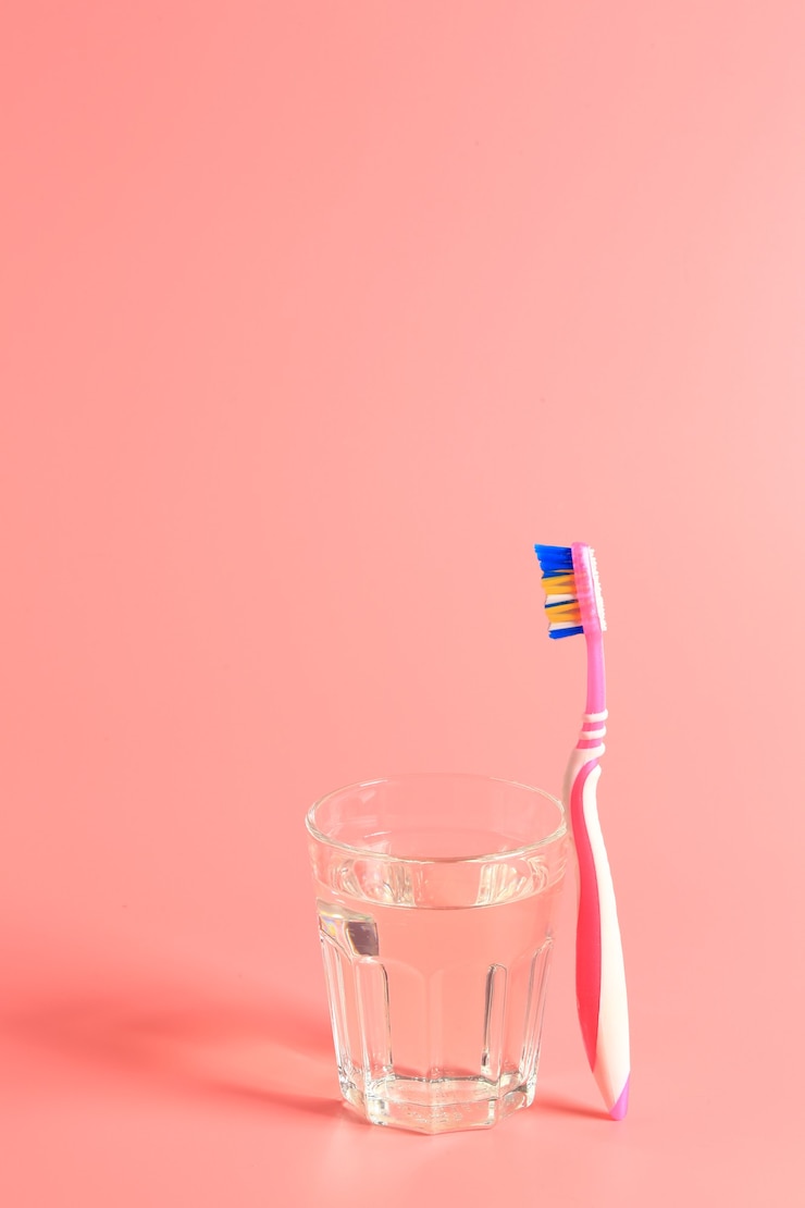 Photo 분홍색 배경에 칫솔과 물 한 잔