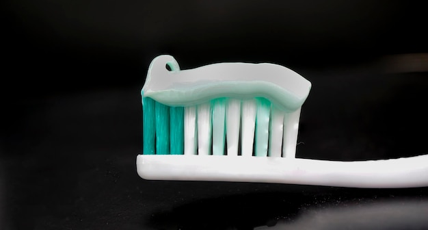 Photo toothbrush and toothpaste on black background