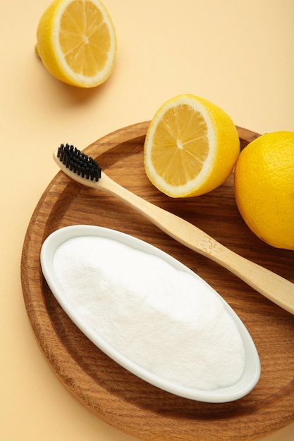 Toothbrush with lemon and baking soda on beige background Vertical photo