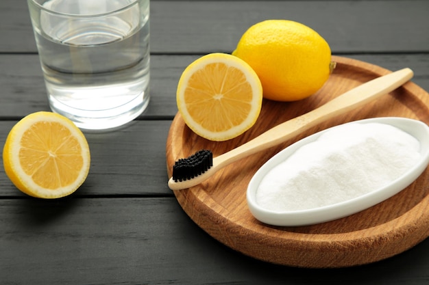 Photo toothbrush with lemon and baking soda on black background