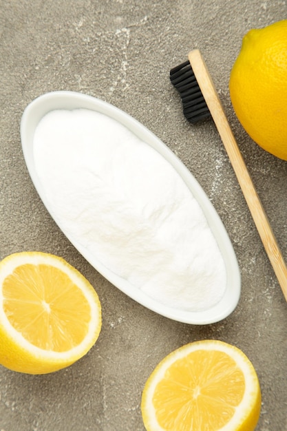 Toothbrush with lemon and baking soda on grey background Vertical photo