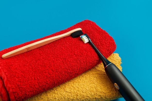Toothbrush with red and yellow towel on blue background