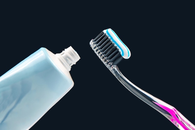 Toothbrush with toothpaste for cleaning teeth on a dark background health care health items