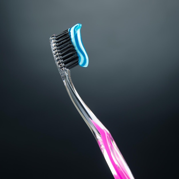 Photo toothbrush with toothpaste for cleaning teeth on a dark background health care health items