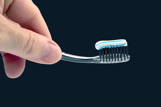 Toothbrush with toothpaste for cleaning teeth on a dark background health care