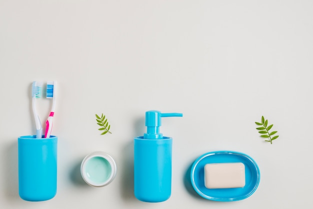 Toothbrushes; cream; soap dispenser and soap on white background