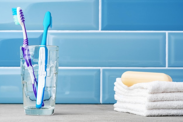 The toothbrushes in a glass in blue bathroom