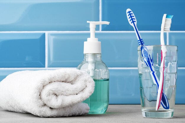 The toothbrushes in a glass in blue bathroom