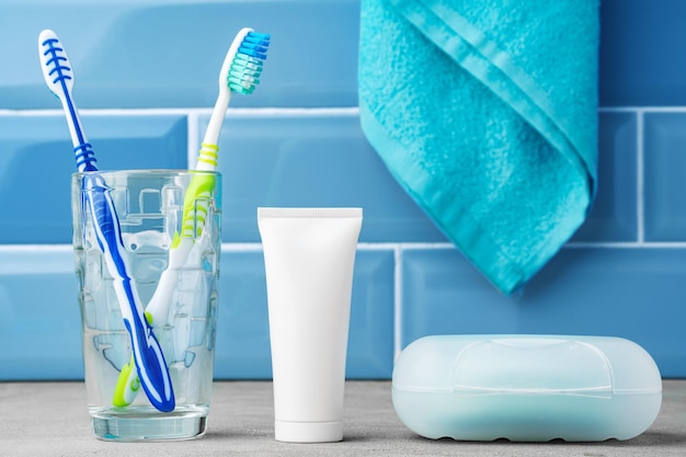 The toothbrushes in a glass in blue bathroom