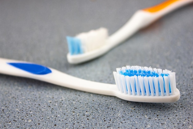 Зубные щетки личные аксессуары на синей раковине стола Зубные щетки крупным планом