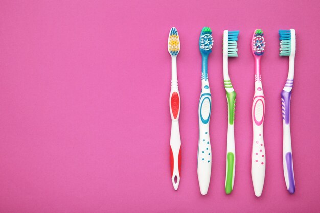 Toothbrushes on pink background isolated