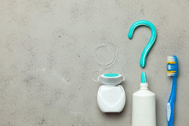Toothpaste in the form of a question mark and toothbrushes and dental floss