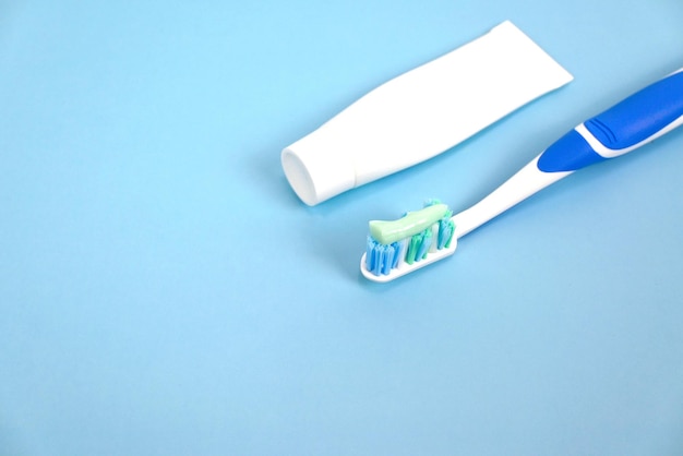 Toothpaste, toothbrush with toothpaste on blue background, health care lifestyle, oral dental care