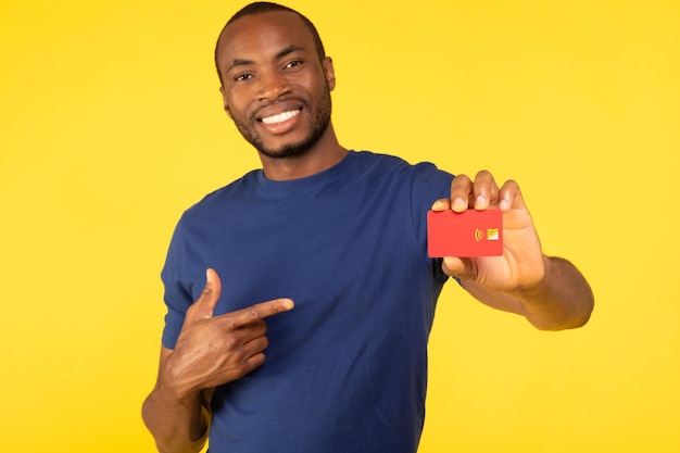 Toothy Black Man Showing Credit Card Advertising Bank Yellow Background