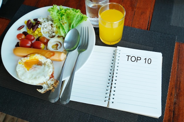 Top 10 woord op notebook met ontbijt op houten tafel