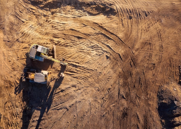 Top aerial view of construction site with tractor and bulldozer.