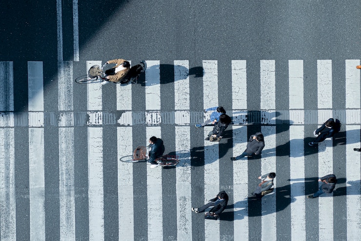 Photo 冬の布で男性と女性のトップからの眺めと通りの横断歩道を自転車に乗る