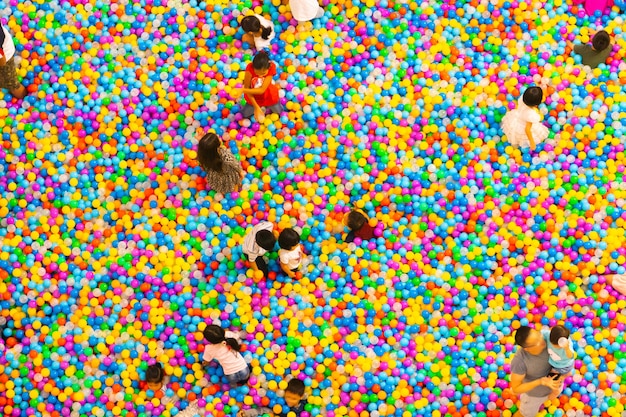 Фото Вид сверху на бассейн с пластиковыми шарами, в котором играют дети и родители
