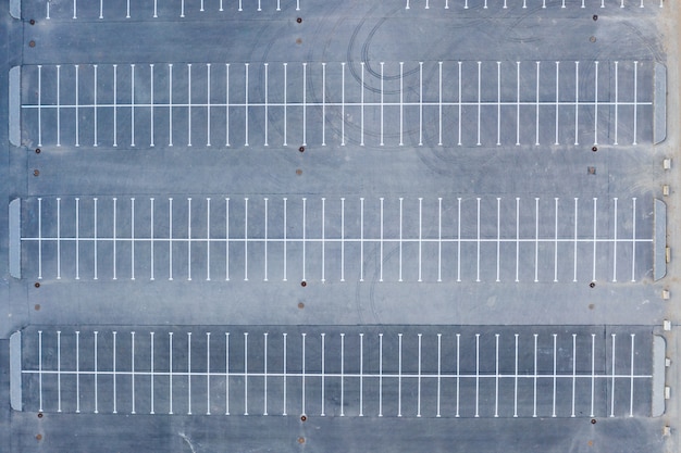 広いエリアの空のアスファルト駐車場への駐車の上面航空写真。