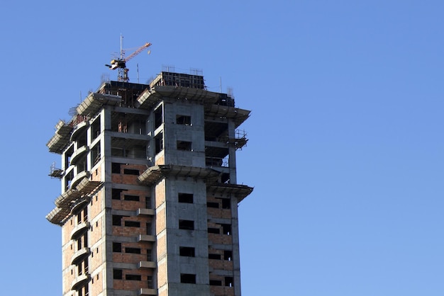 Top of a building under construction with concrete and bricks on display blue sky background