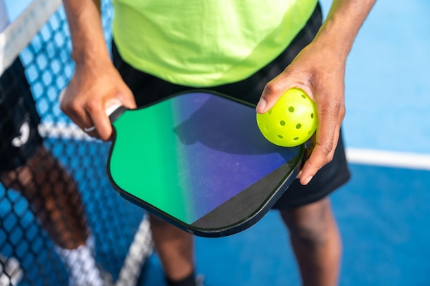 Top close-up van een man met een racket en een pickleballbal