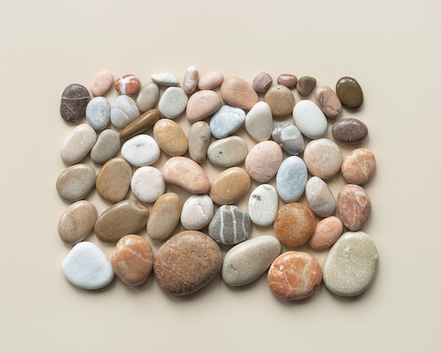 Top close-up view kiezels zee stenen op zand kleur achtergrond vierkante compositie van natuursteen natuurtonen Minimal stijl plat leggen concept van rustige meditatie Creatief zomer patroon