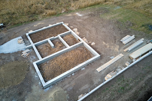 Top down aerial view of building works of new house concrete foundation on construction site