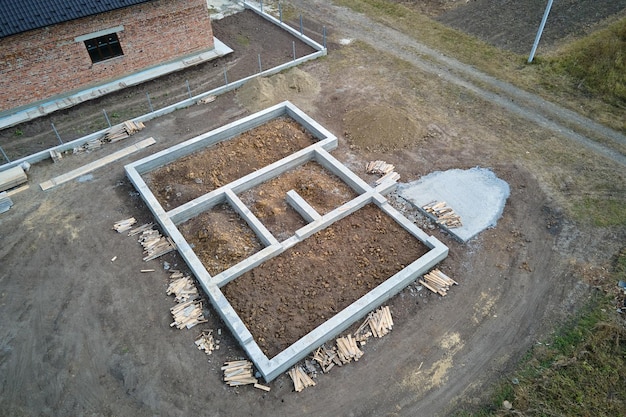 Top down aerial view of building works of new house concrete foundation on construction site