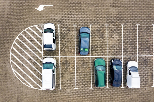 Vista aerea dall'alto verso il basso di molte auto in un parcheggio del supermercato o in vendita sul mercato del concessionario auto.