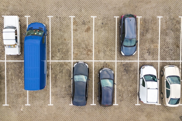 Vista aerea dall'alto verso il basso di molte auto su un parcheggio di un supermercato o sul mercato dei rivenditori di auto in vendita.