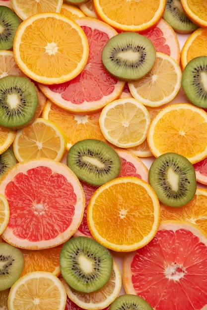 Top down background view made of fresh sliced organic kiwi oranges and lemons closeup