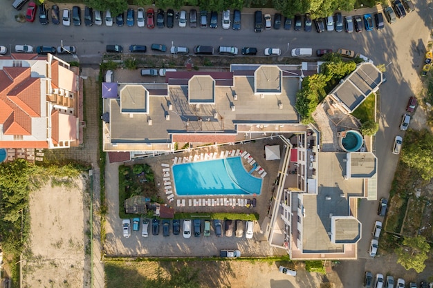 Top-down luchtfoto van hotels daken, straten met geparkeerde auto's en zwembaden met blauw water in resort stad in de buurt van de zee.