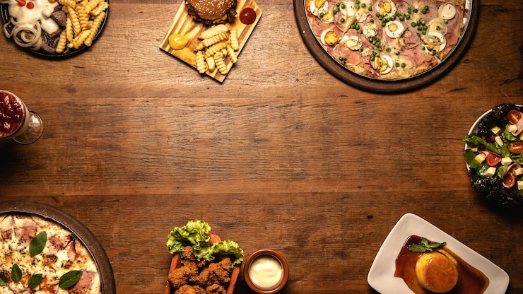 Photo top down of tasty meals on a wooden cutting board with pizza fried chicken hamburger and steak